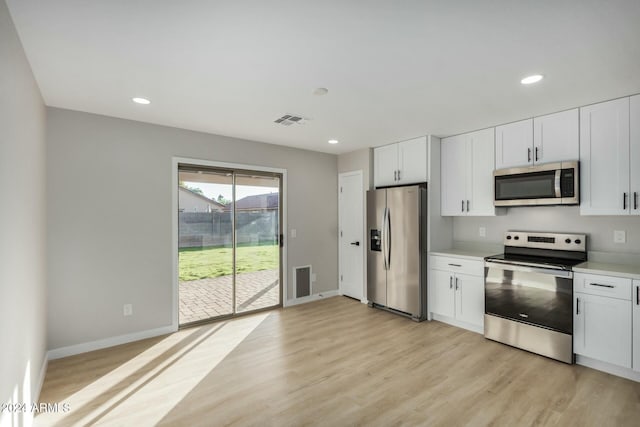 kitchen featuring light hardwood / wood-style flooring, white cabinets, and appliances with stainless steel finishes