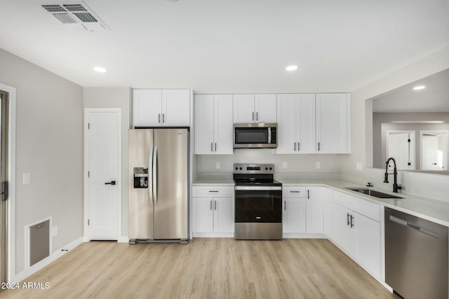 kitchen featuring white cabinets, light hardwood / wood-style floors, sink, and appliances with stainless steel finishes