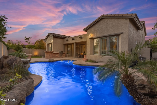 pool at dusk featuring a patio