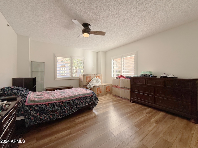 bedroom featuring a textured ceiling, light hardwood / wood-style flooring, and ceiling fan