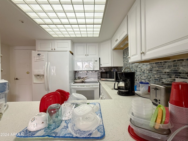 kitchen featuring white cabinets, decorative backsplash, and white appliances