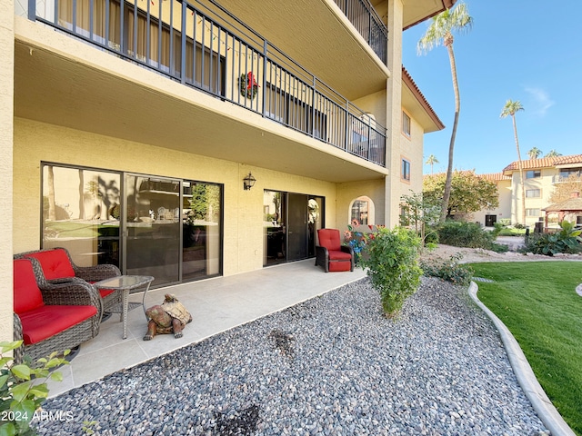 rear view of property featuring a balcony and a patio area