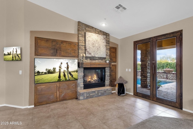 living room with french doors, a stone fireplace, vaulted ceiling, and light tile patterned floors