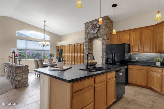 kitchen with sink, light tile patterned floors, black appliances, and a center island with sink