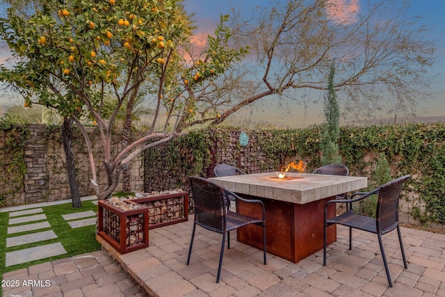 patio terrace at dusk featuring a fire pit