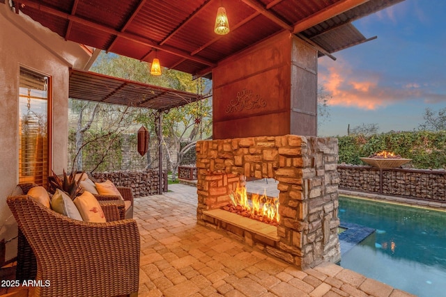 patio terrace at dusk with an outdoor stone fireplace