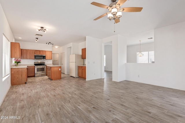 6350 W Hess St, Phoenix, AZ 85043 - kitchen featuring stainless steel appliances, decorative light fixtures, a kitchen island, and light wood-type flooring