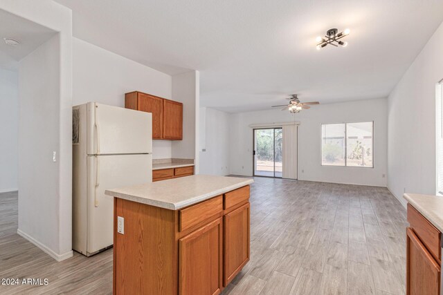 6350 W Hess St, Phoenix, AZ 85043 - kitchen with ceiling fan, a kitchen island, white fridge, and light wood-type flooring