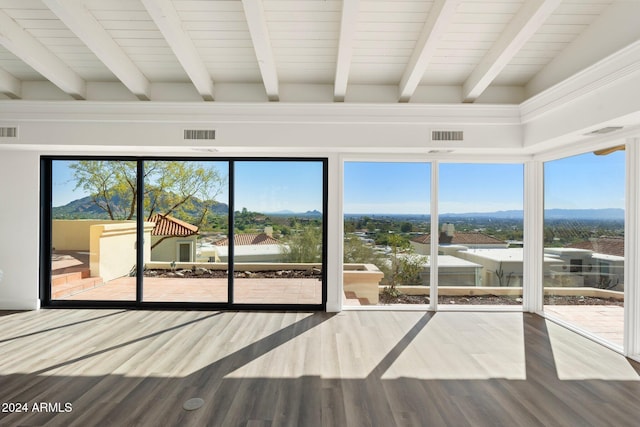 unfurnished sunroom with a mountain view, beam ceiling, and a wealth of natural light