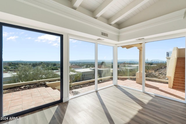 unfurnished sunroom with vaulted ceiling with beams