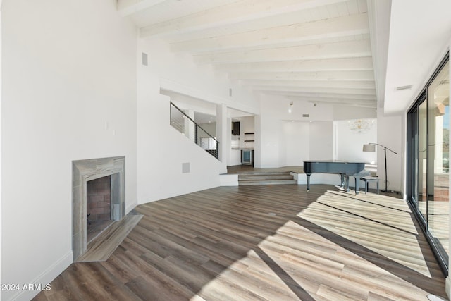 unfurnished living room with hardwood / wood-style floors, beam ceiling, and a high end fireplace