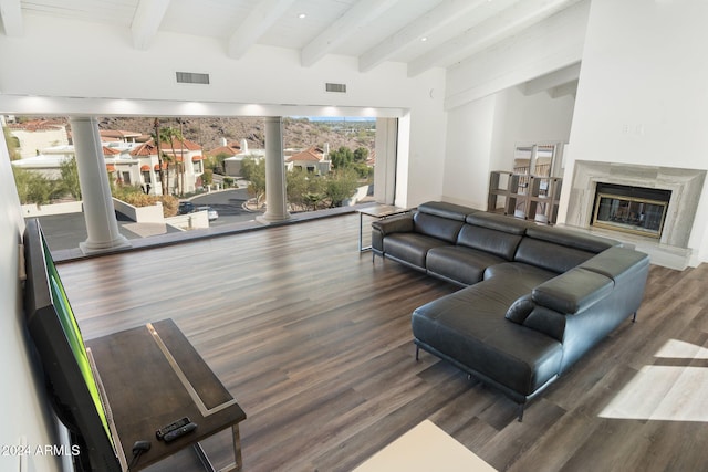 living room with beamed ceiling, dark hardwood / wood-style flooring, decorative columns, and a premium fireplace