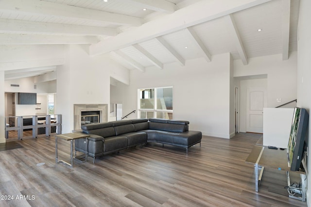 living room with beam ceiling, hardwood / wood-style flooring, high vaulted ceiling, and a premium fireplace