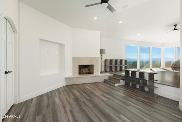 unfurnished living room with a high end fireplace, dark hardwood / wood-style flooring, and ceiling fan