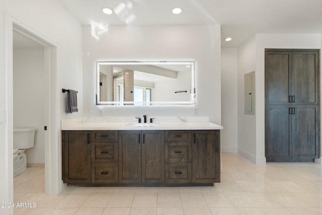 bathroom with tile patterned floors, vanity, electric panel, and toilet