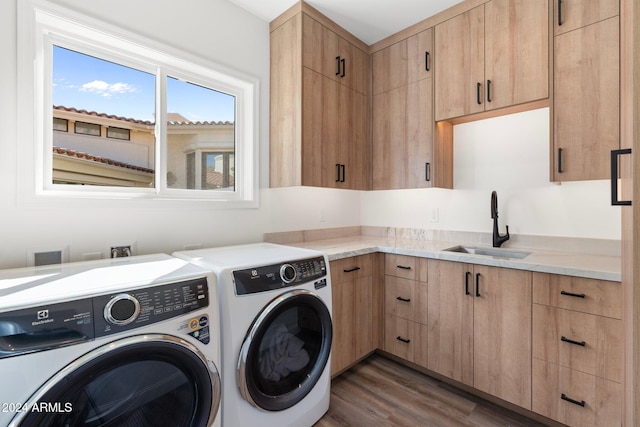 washroom with dark hardwood / wood-style floors, cabinets, sink, and washing machine and clothes dryer