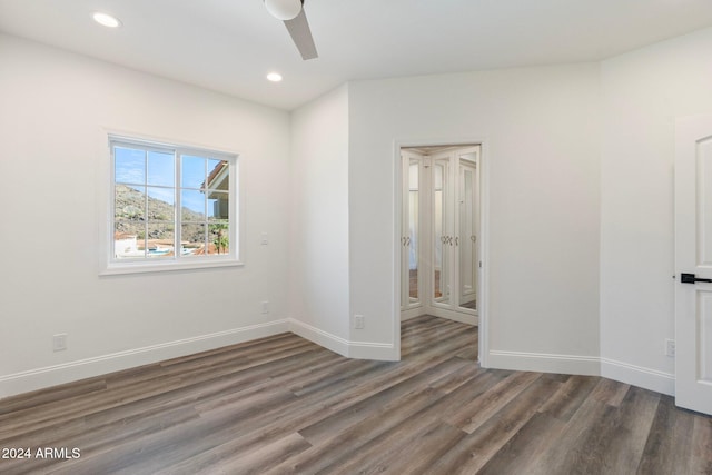 unfurnished room with dark hardwood / wood-style flooring and ceiling fan