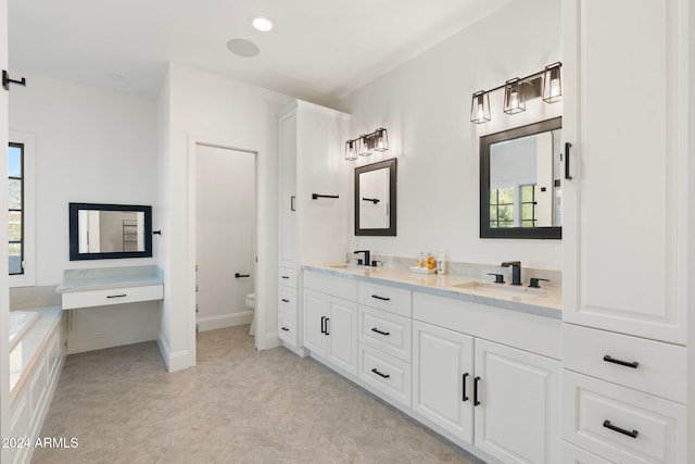 bathroom with vanity, a tub to relax in, and toilet