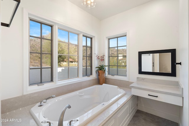 bathroom with tiled bath and a chandelier