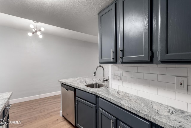 kitchen featuring sink, light stone countertops, decorative backsplash, stainless steel dishwasher, and light wood-type flooring