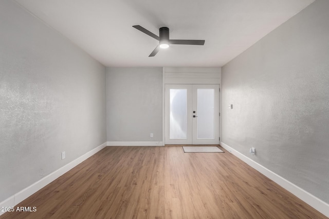 spare room featuring french doors, ceiling fan, and light hardwood / wood-style flooring