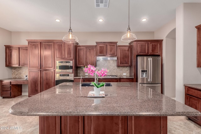 kitchen featuring dark stone countertops, stainless steel appliances, sink, and a large island