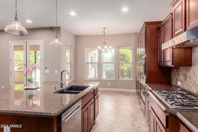 kitchen with a center island with sink, hanging light fixtures, stainless steel appliances, and sink