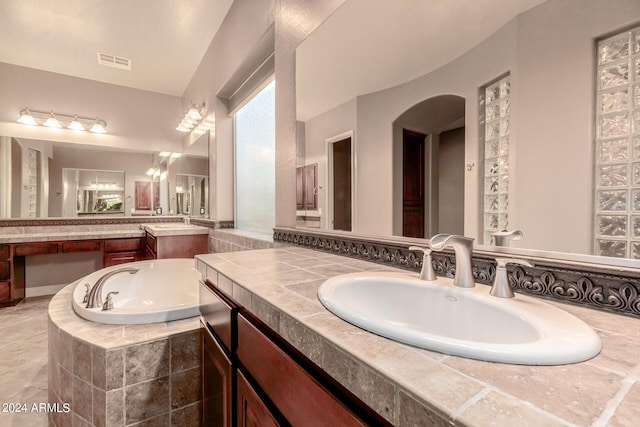 bathroom with vanity and a relaxing tiled tub