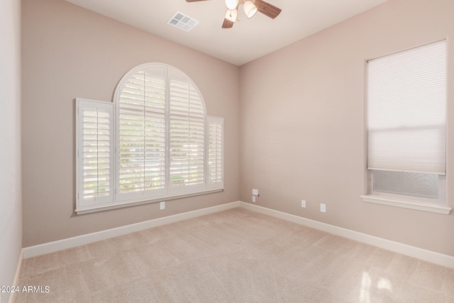 spare room featuring ceiling fan and light carpet