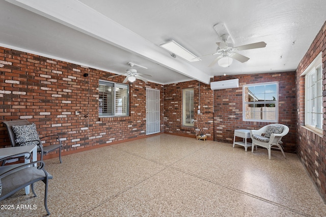 sunroom featuring a ceiling fan, beam ceiling, and a wall mounted air conditioner