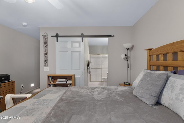 bedroom featuring a barn door and ensuite bathroom