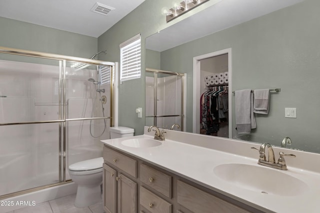 bathroom featuring vanity, toilet, tile patterned floors, and walk in shower