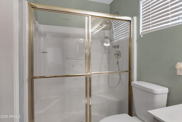 bathroom featuring an enclosed shower, vanity, and toilet