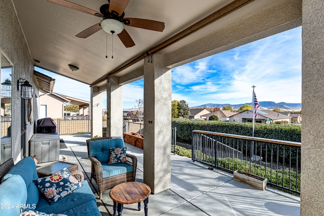 view of patio with outdoor lounge area, a mountain view, and ceiling fan