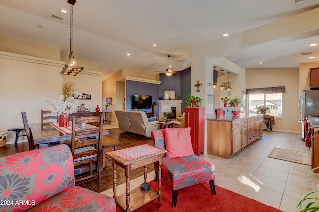 living room with ceiling fan, lofted ceiling, and light tile patterned flooring