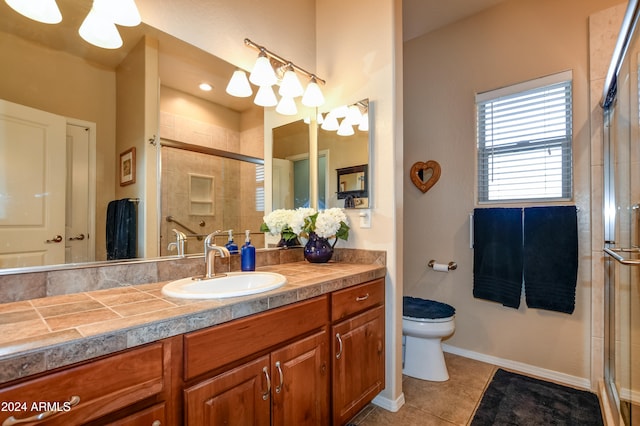 bathroom featuring tile patterned flooring, vanity, toilet, and walk in shower