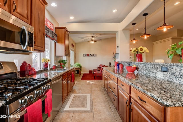 kitchen featuring ceiling fan, dark stone counters, decorative light fixtures, light tile patterned flooring, and appliances with stainless steel finishes