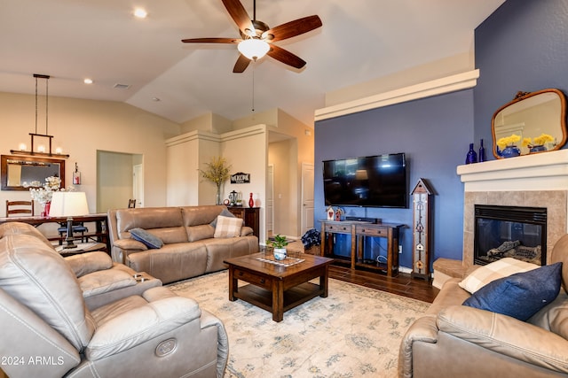 living room with ceiling fan, lofted ceiling, a tile fireplace, and light hardwood / wood-style flooring