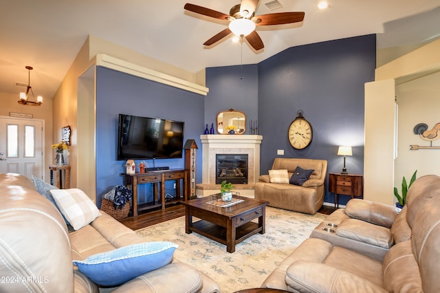 living room featuring ceiling fan with notable chandelier, light wood-type flooring, and lofted ceiling