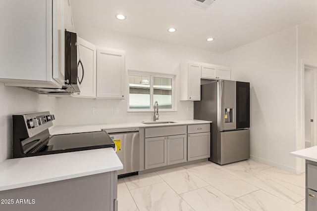 kitchen with visible vents, appliances with stainless steel finishes, a sink, light countertops, and marble finish floor