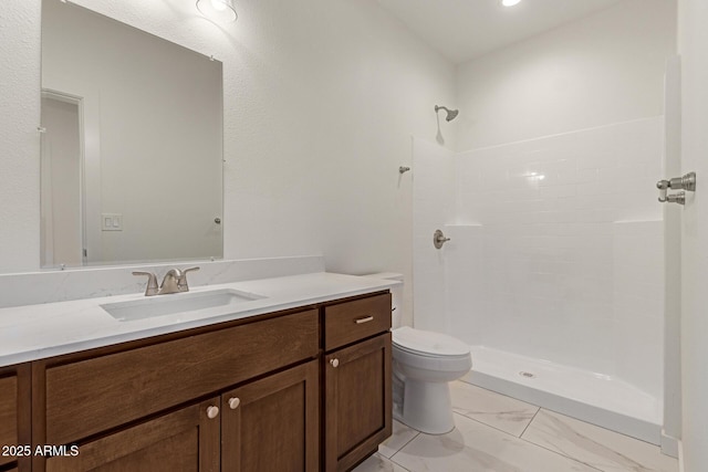 full bath featuring vanity, a tile shower, toilet, and marble finish floor