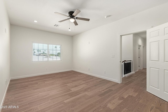 unfurnished room with visible vents, a ceiling fan, light wood-style flooring, and baseboards
