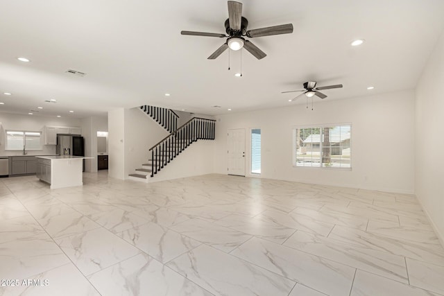 unfurnished living room featuring visible vents, baseboards, stairway, recessed lighting, and a ceiling fan