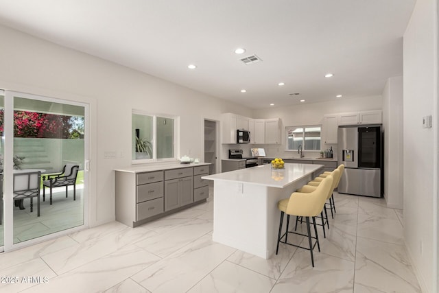 kitchen with recessed lighting, appliances with stainless steel finishes, visible vents, and marble finish floor