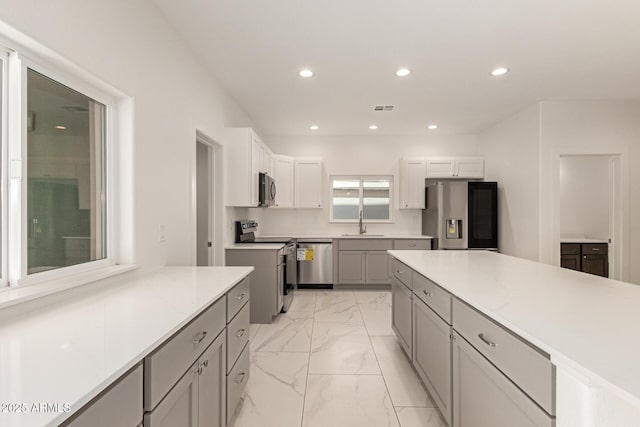 kitchen with visible vents, marble finish floor, recessed lighting, appliances with stainless steel finishes, and gray cabinetry
