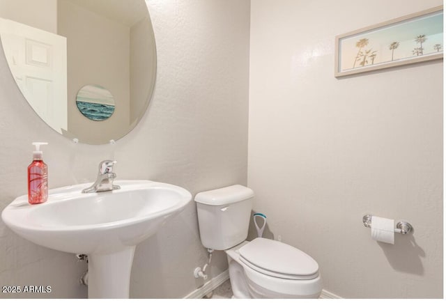 half bath with toilet and baseboards