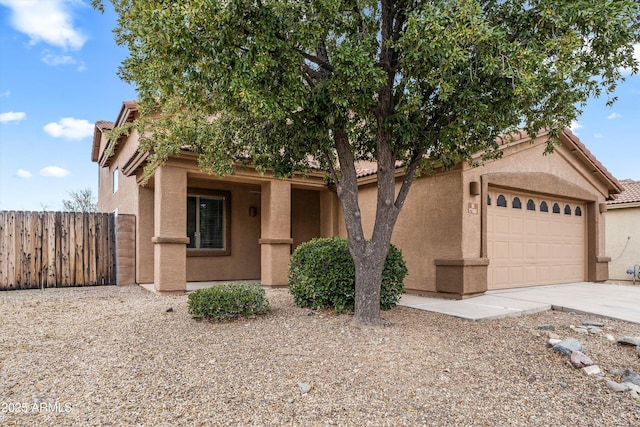 view of front facade featuring stucco siding, concrete driveway, fence, a garage, and a tiled roof