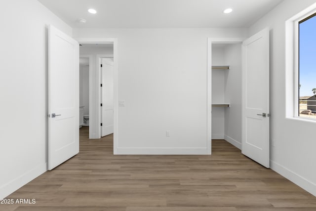 2689 S 305th Ave, Buckeye, AZ 85326 - unfurnished bedroom featuring multiple windows, baseboards, recessed lighting, light wood-style flooring, and a spacious closet