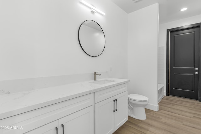 2689 S 305th Ave, Buckeye, AZ 85326 - bathroom with toilet, wood finished floors, vanity, a tub, and baseboards
