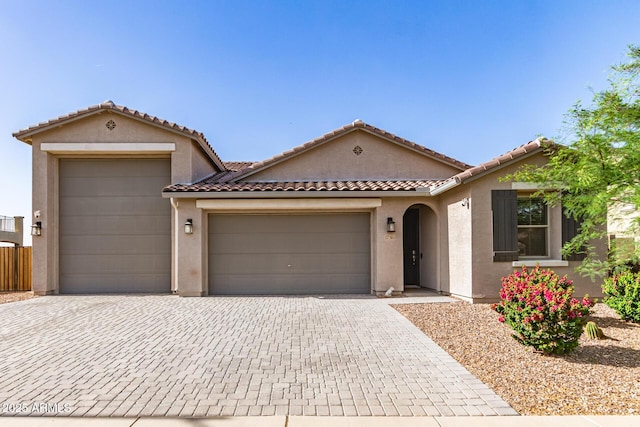 1736 E Joelle Dr, Casa Grande, AZ 85122 - mediterranean / spanish-style home featuring a garage, decorative driveway, stucco siding, and a tile roof